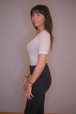 Açık renk uzun saçlı, beyaz tişörtlü, siyah saçlı güzel bir kız.