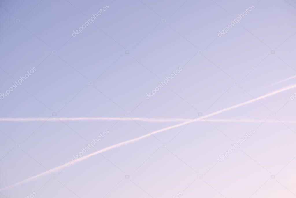 airplane contrails in the sunset sky chemtrails