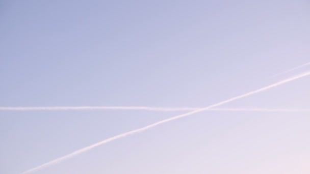 Uçak günbatımında zıt düşüyor. Gökyüzü kimyasal izleri. — Stok video