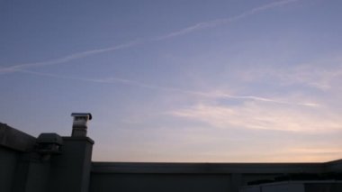 Uçak günbatımında zıt düşüyor. Gökyüzü kimyasal izleri.