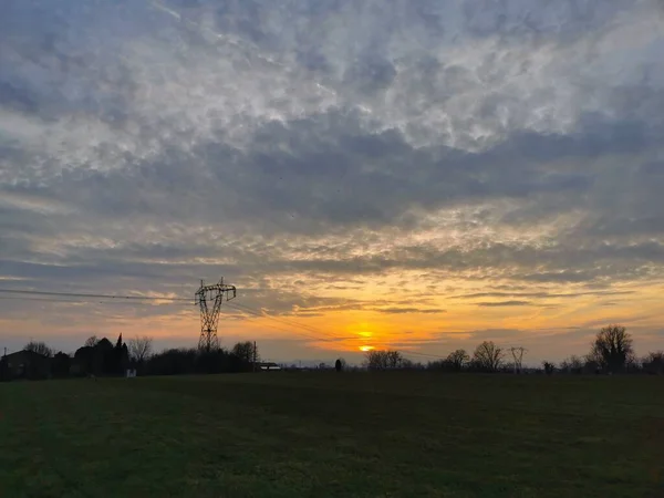 Een Zonsondergang Boven Een Grasveld Met Wolken Aan Hemel Hoge — Stockfoto