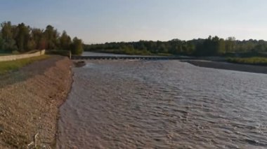 Montecchio Emilia 'daki Enza Nehri. Köprüden sel basmış. Gün batımında kirli suyla dolmuş.