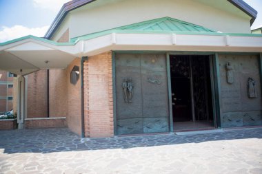 Güneşli bir günde kilisenin önündeki kaldırımda.