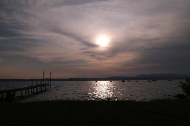 Sirmione sahilinden gün batımında Garda Gölü.