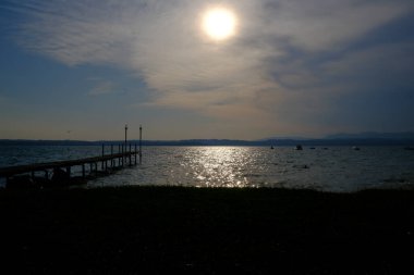 Sirmione sahilinden gün batımında Garda Gölü.
