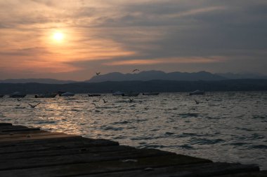 Sirmione sahilinden gün batımında Garda Gölü.
