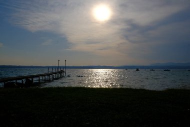 Sirmione sahilinden gün batımında Garda Gölü.