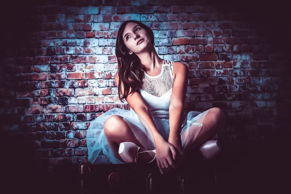 Menina bonita posando com vestido de dança branco tutu para foto no tronco — Fotografia de Stock