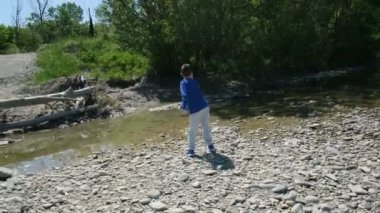 Güzel çocuk köprüden nehre taş atıyor. 2. aşama Crown virüsü kilitleniyor.