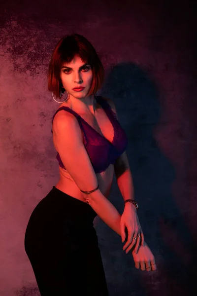 Belle fille italienne aux cheveux courts posant en studio photo avec des lumières colorées en sous-vêtements sexy — Photo