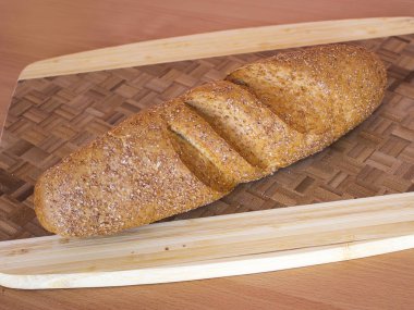 Kesme tahtasının üzerinde bir somun ekmek yatıyor. Yukarıdan görüntüle.