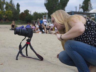 Kız videocu, nehir kıyısında bir haber yapıyor.