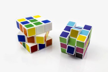 Beyaz arka planda iki rubik küp. Eğitici düşünme bulmacası.