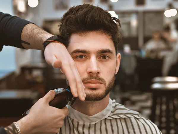 Руки молодого перукаря, що робить зачіску привабливою людиною в перукарні — стокове фото