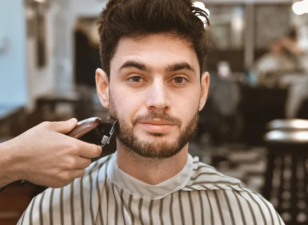Руки молодого перукаря, що робить зачіску привабливою людиною в перукарні — стокове фото
