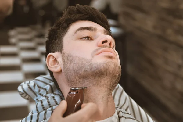 Shave beards in barbercos. A beautiful guy shaves a beard. Body care.