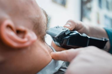 Kuaför sakalını tıraş için istemci makineye fırlattı. İstemcinin sakalın mükemmel şeklini alır. Yumuşak odak.