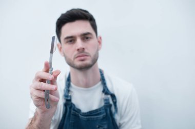 Tıraş Studio için tehlikeli ustura ile şık Kuaför. Sakallı yakışıklı, seksi maço elinde ustura ile. Güzellik endüstri ve ev cilt bakım kavramı. Kopya alanı için reklam berber dükkanı. F