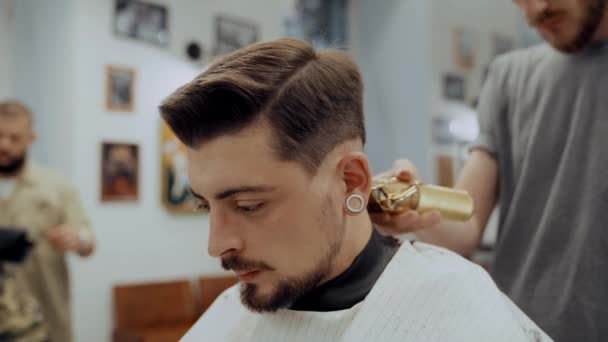 Nahaufnahme Porträt eines attraktiven jungen Mannes mit modischem Haarschnitt. — Stockvideo