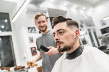 Berberde berberle gülümseyen bir müşteri. Eğlenceli berber..