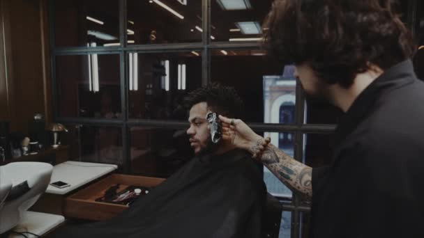 Coupe de cheveux d'un homme dans un salon de coiffure vintage en verre brun . — Video