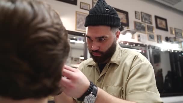 El cliente recibe un corte de pelo en una peluquería. Cuidado del cabello para hombre . — Vídeo de stock