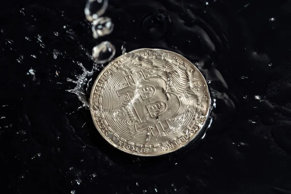 Monedas de criptomoneda sobre un fondo oscuro. Gotas de lluvia sobre monedas . — Foto de Stock