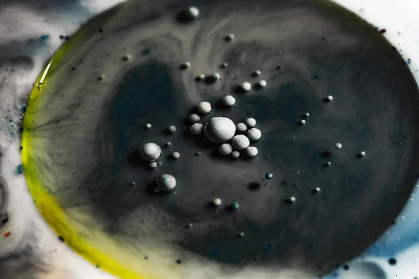 Färgutvinning av olja i vatten. En närbild av ett runt objekt. — Stockfoto