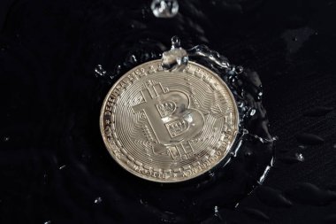 Karanlık arka planda kripto para birimleri. Bozukluklara yağmur damlaları.