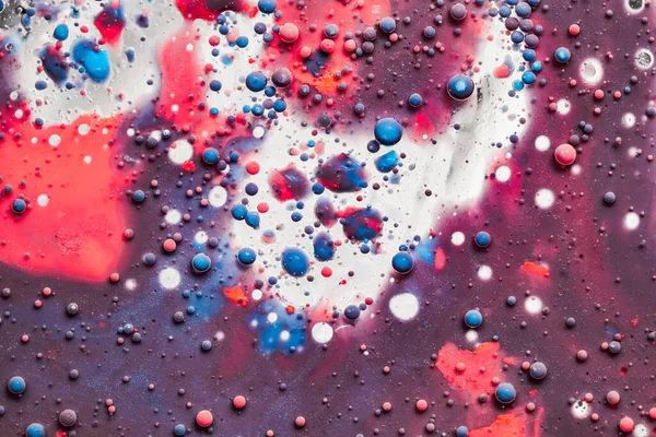 Gotas de cor flutuando em óleo e água sobre um colorido subterrâneo com efeito de pintura a óleo . — Fotografia de Stock
