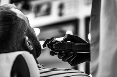 Berber dükkanında erkek tıraşı. Antivirüs maskeli müşteri ve berber. 