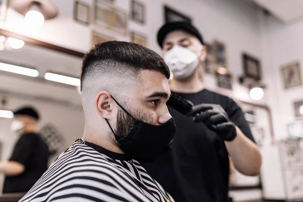 Corte de pelo para hombre en una peluquería. Estilismo y cuidado del cabello . — Foto de Stock