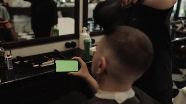 O barbeiro corta o cabelo aos clientes. Corte de cabelo dos homens em uma barbearia . — Vídeo de Stock