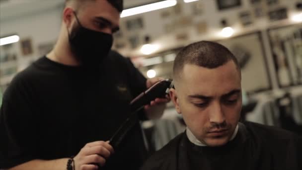 Barber corta el pelo de los clientes. Corte de pelo para hombre en una peluquería . — Vídeo de stock