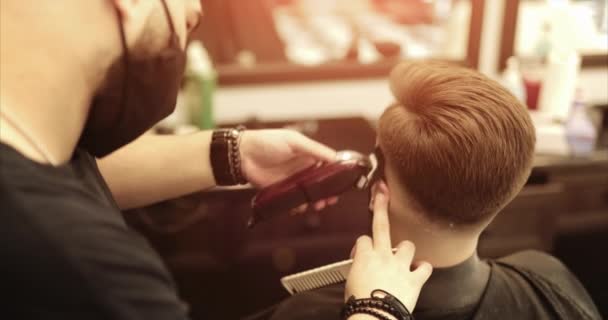 Der Friseur schneidet sich im Friseursalon mit einem Haarschneider die Haare ab. — Stockvideo