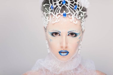Yeni yıl için yaratıcı makyajlı güzel bir kız. Kış portresi. Parlak renkler, mavi dudaklar, zarif elbise tasarımı saç. Kavramsal sanat. Kar Kraliçesi.