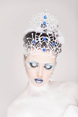 Yeni yıl için yaratıcı makyajlı güzel bir kız. Kış portresi. Parlak renkler, mavi dudaklar, zarif elbise tasarımı saç. Kavramsal sanat. Kar Kraliçesi.