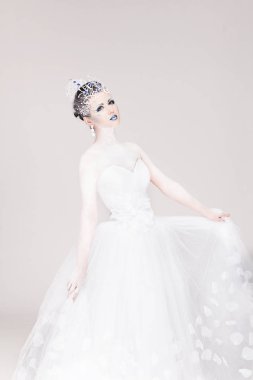 Yeni yıl için yaratıcı makyajlı güzel bir kız. Kış portresi. Parlak renkler, mavi dudaklar, zarif elbise tasarımı saç. Kavramsal sanat. Kar Kraliçesi.