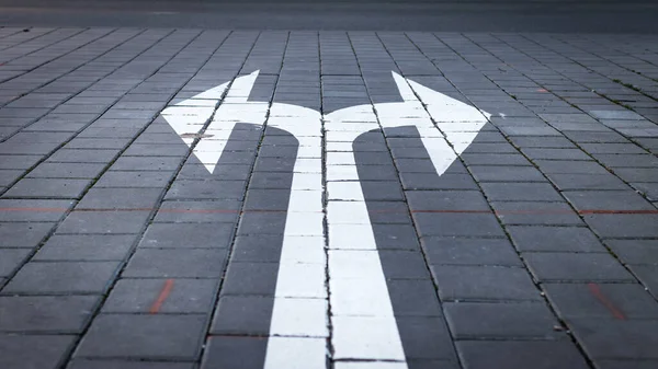 Arrow symbol on forked road. Make choice which way to go. Directional traffic arrow sign on street. Decision concept.