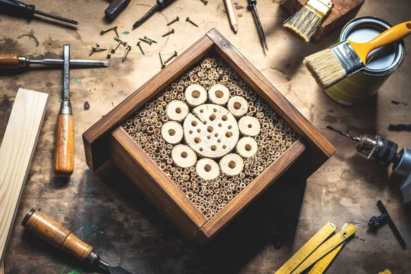 Böcek oteli ya da atölyedeki ahşap masanın üzerindeki ev. Ev yapımı el yapımı ürünler. DIY kavramı