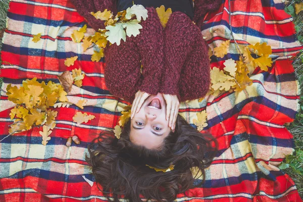 Frau liegt in Blättern — Stockfoto