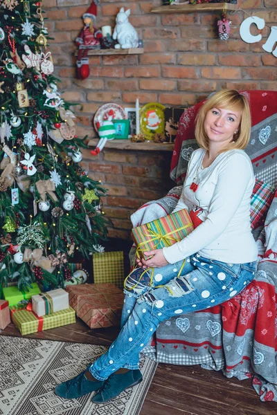 Hermosa chica sosteniendo un regalo de Navidad delante de ella — Foto de Stock