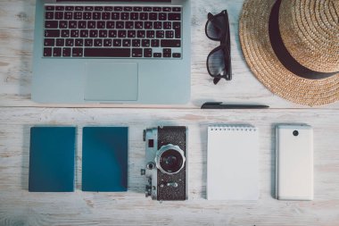 Dizüstü bilgisayar, şapka, gözlük, akıllı telefon, kamera ile beyaz yüzey Üstten Görünüm