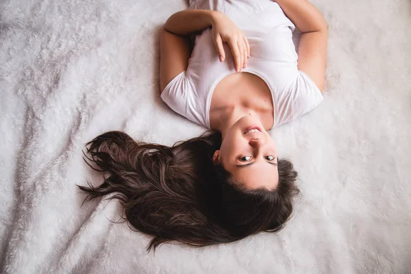 Jovem mulher cabelo muito escuro na cama — Fotografia de Stock