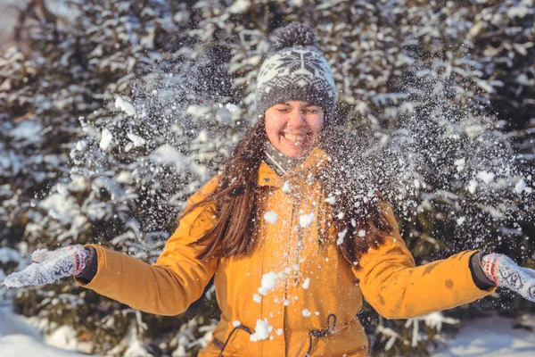 Schöne Winterfrau spielt mit Schnee — Stockfoto