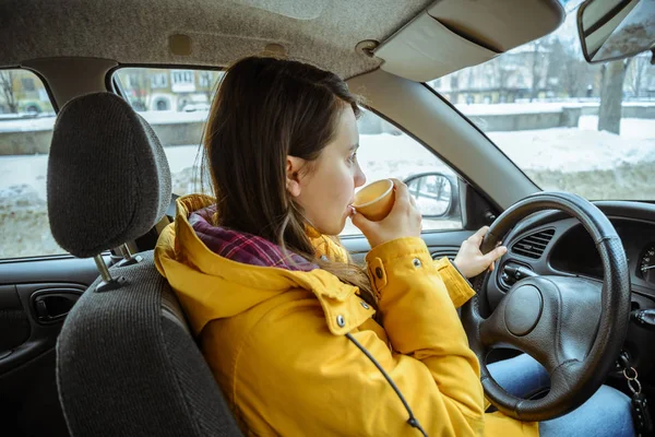 Charming businesswoman drinking cup while driving to work — Stock Photo, Image