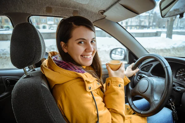 Charming businesswoman drinking cup while driving to work — Stock Photo, Image