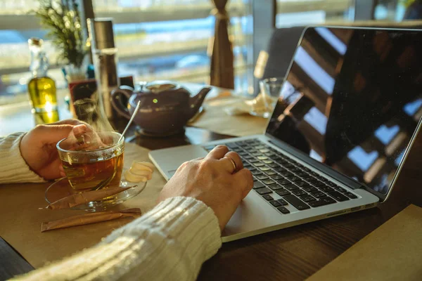 Male sitiing in caffe drinking tea and working on laptop — Stock Photo, Image