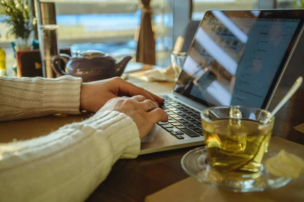 Male sitiing in caffe drinking tea and working on laptop — Stock Photo, Image