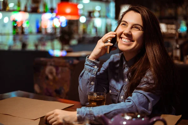 Porträtt av vacker flicka med sin mobiltelefon i café. — Stockfoto
